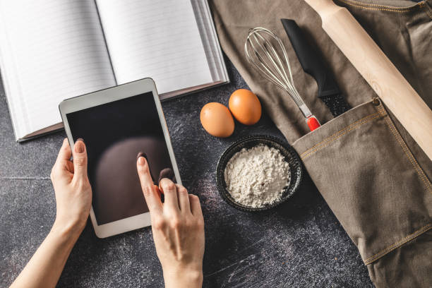 istock Digital tablet, cookbook and kitchen utensil 1211563416