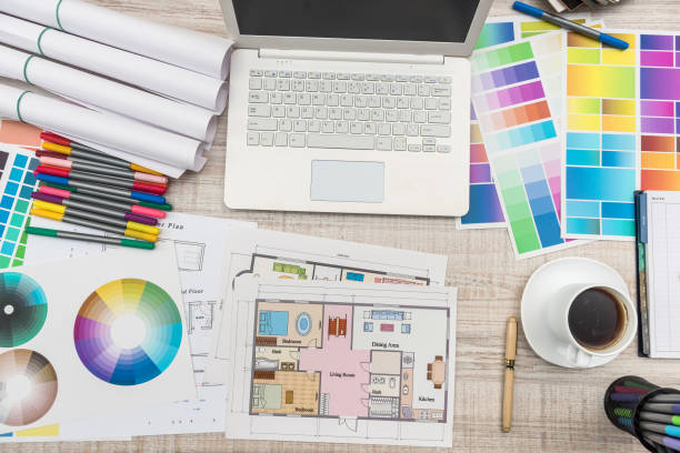 close up view of color palette swatch and house building plans on office desk with laptop and cup of coffee for break - home decorating fabric swatch color swatch blueprint imagens e fotografias de stock