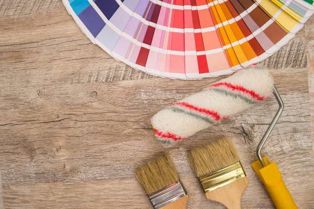 istock Color palette guide and paint brush roller  on wood board. 1211566565