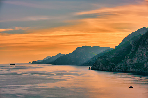 Looking from above along the Amalfi coastline during sunset. Its rapidly raise hundreds of meters above sea level, because of the geographical reasons. The Amalfi coast is a stretch of coastline on the northern coast of the Salerno Gulf on the Tyrrhenian Sea, located in the Province of Salerno of southern Italy. The Amalfi Coast is a popular tourist destination for the region and Italy as a whole, attracting thousands of tourists annually. In 1997, the Amalfi Coast was listed as a UNESCO World Heritage Site.