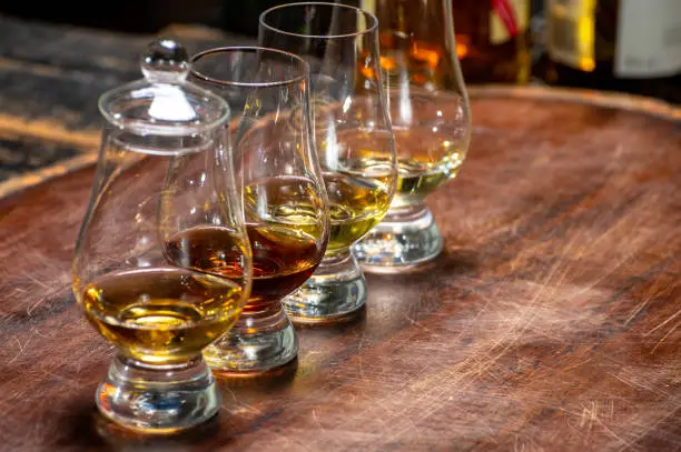 Tasting of flight of Scotch whisky from special tulip-shaped glasses on distillery in Scotland, UK close up