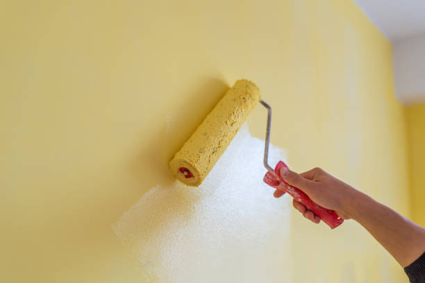 istock Workman painting the wall in yellow. 1211569921