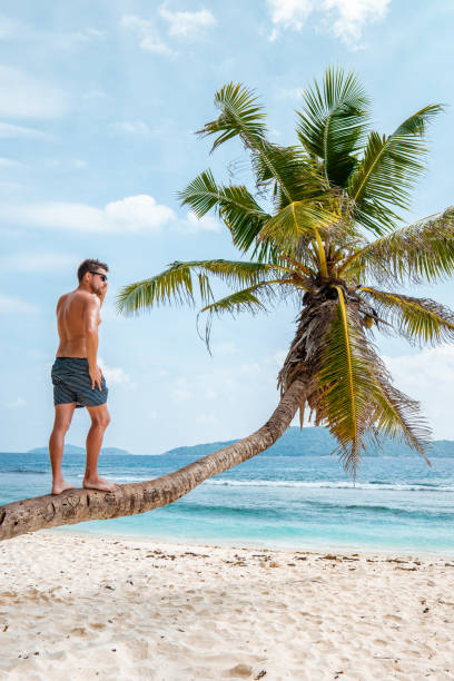 istock La Digue Seychelles,young man in casual clothes on the beach at Anse Source d'Argent, LA Digue Seychelles , near Praslin and Mahe Island 1211570899