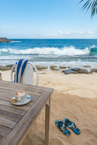 istock Cup of coffee on tropical beach 1211573714