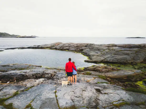 Photo of Family enjoying the view of scenic landscape at the seacoast of Northern Norway