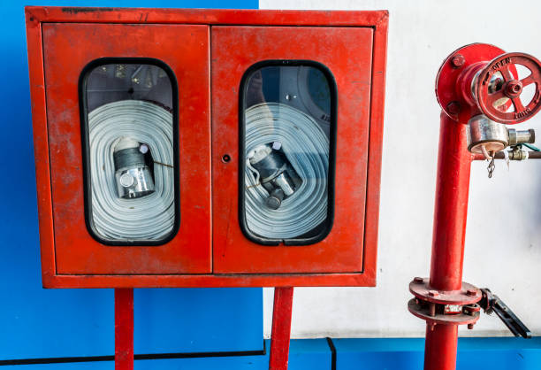 Wall Hanging Fire Extinguisher, Fire Safety and Emergency Equipment install in Red Blue Box wall mount arctural fire extinguisher glass cabinet in a Industrial building.