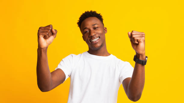 istock Young cheerful african guy moving dancing on yellow 1211578177