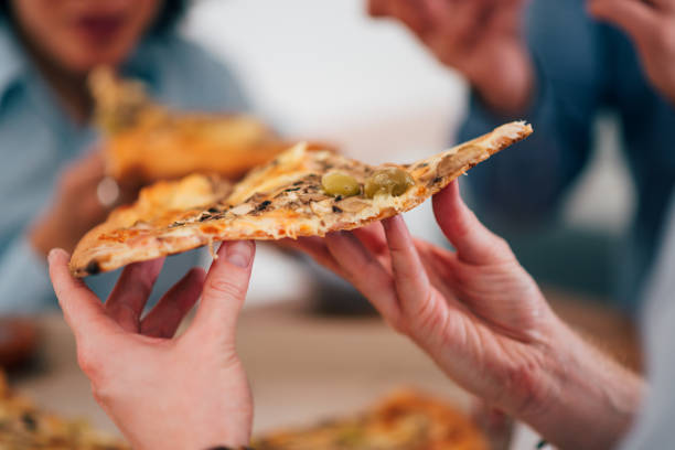 istock Eating pizza with friends, close-up. 1211579405