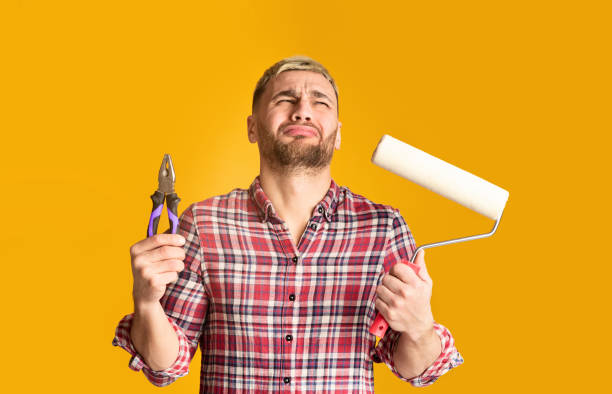 istock Man suffers with pliers and roller at his hands 1211579598