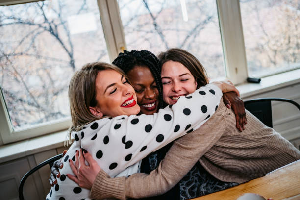 istock Three women friends embracing in cafe 1211581104