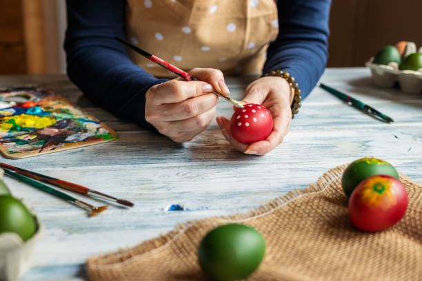 istock Woman painting egg and preparing for Easter holiday celebration 1211581557