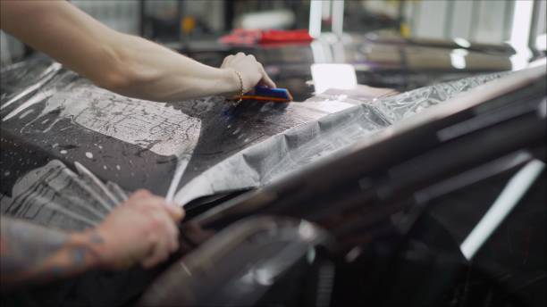 istock closeup peeling off protective film from a car 1211582311