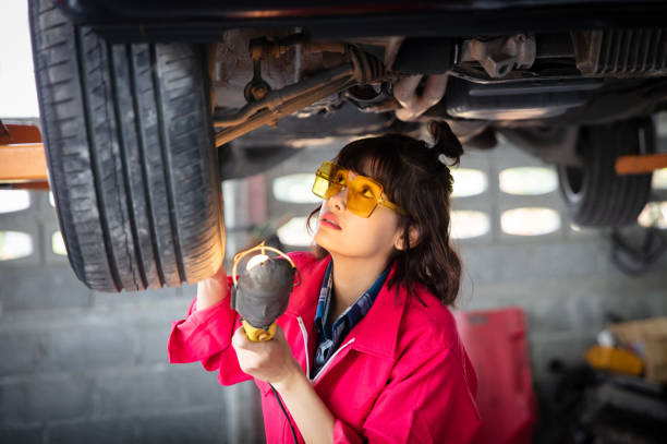 istock Femele Technician concentrate checking underbody of car 1211582397