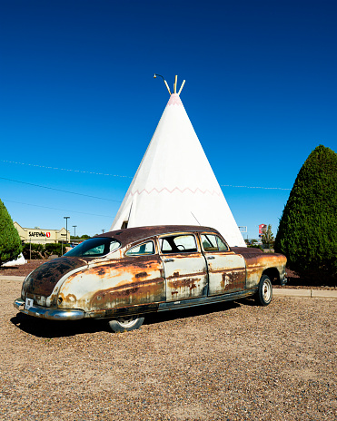 Holbrook, Arizona USA - October 6, 2019: The iconic and vintage Wigwam Motel, a popular southwestern tourist destination, with American Indian teepee style motel rooms and classic cars along the historic Highway Route 66.