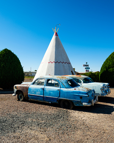Holbrook, Arizona USA - October 6, 2019: The iconic and vintage Wigwam Motel, a popular southwestern tourist destination, with American Indian teepee style motel rooms and classic cars along the historic Highway Route 66.