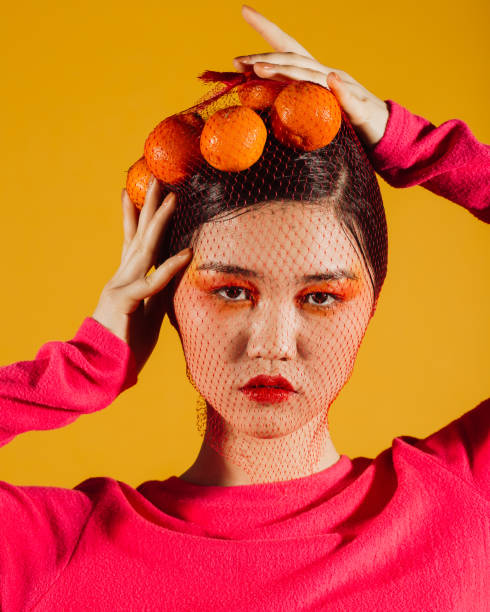 istock Young asian woman with tangerines 1211585080