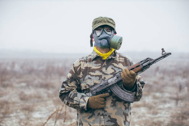 istock Soldier with gas mask and automatic gun standing ready 1211585119