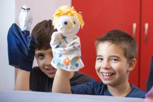 two little boys playing with puppets