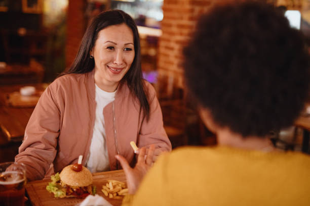 istock Mature women having a drink in a pub 1211586181