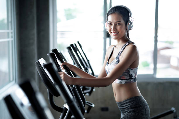joven mujer sana cardio en una cinta de correr en el gimnasio. - run of the mill fotografías e imágenes de stock