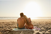 Young couple in swimwear looking at the ocean in the late afternoon