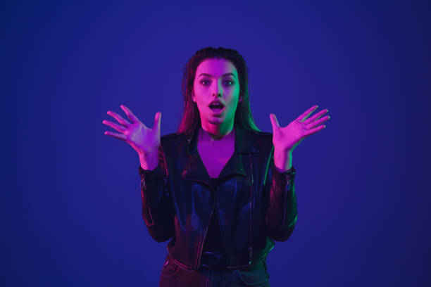 istock Caucasian woman's portrait isolated on blue studio background in neon light 1211589017