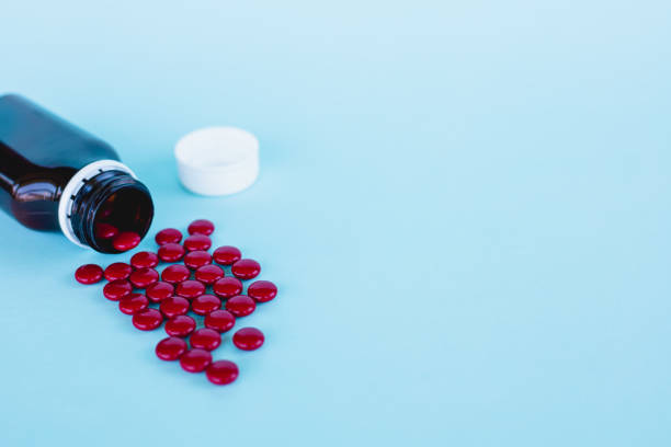 blood tonic includes multivitamins, folic acid, and iron liquid with bottle on blue background for healthcare and medical concept - antibiotic red medicine healthcare and medicine imagens e fotografias de stock