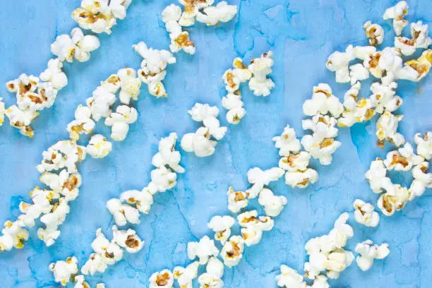 Salty butter popcorn laying on the blue grunge background