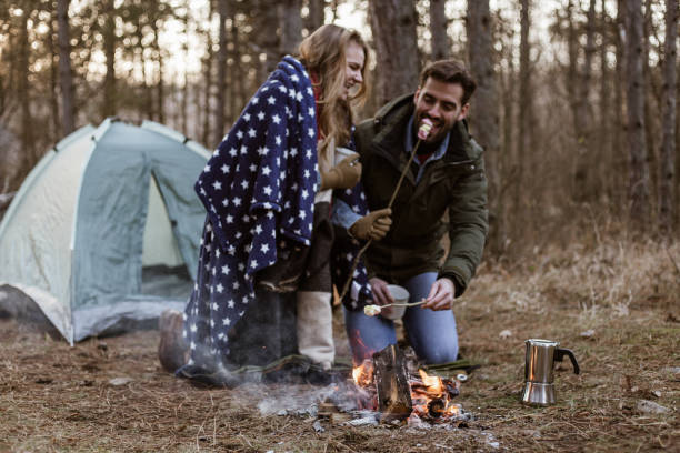 istock Lovely couple enjoying their camping in nature while eating and roasting marshmallow 1211591004