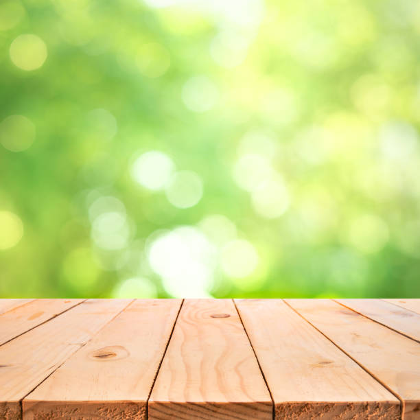 istock Real wood table top texture on blur leaf tree garden background.For create product display or design key visua 1211591513