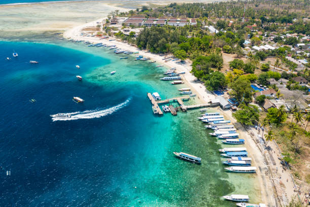 Aerial view of boats moored off a beautiful tropical coral reef and beach on a small island (Gili Air, Indonesia) Aerial view of boats moored off a beautiful tropical coral reef and beach on a small island (Gili Air, Indonesia) gili trawangan stock pictures, royalty-free photos & images