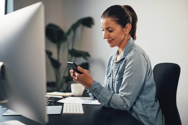 istock Smiling businesswoman sending a text message on her cellphone 1211594171