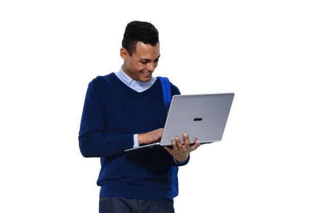 istock Generation z young male standing in front of white background wearing jeans and using computer 1211594228