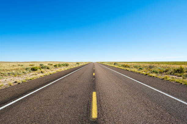 strada del deserto - arid climate asphalt barren blue foto e immagini stock