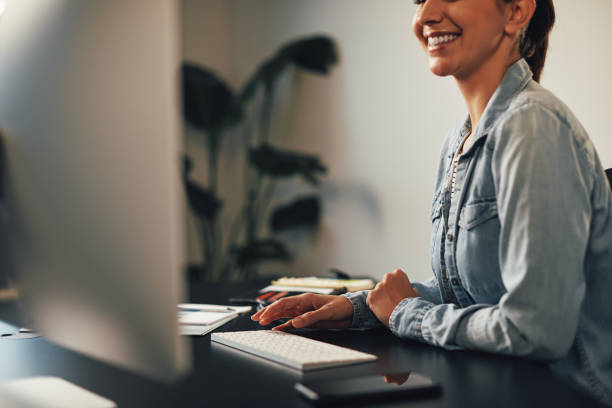 istock Smiling businesswoman working on a computer at her desk 1211594411