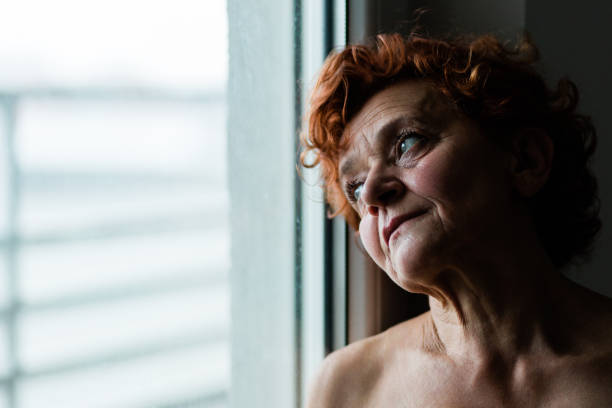 istock Mature woman by the window thinking about life 1211594727