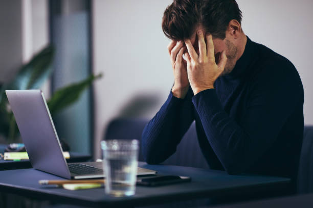 istock Young businessman looking stressed at his desk in an office 1211595277
