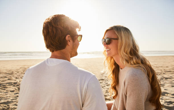 istock Young couple relaxing together on a beach on a sunny afternoon 1211595293