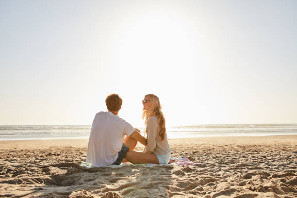 istock Young couple enjoying a sunny afternoon at the beach 1211595455