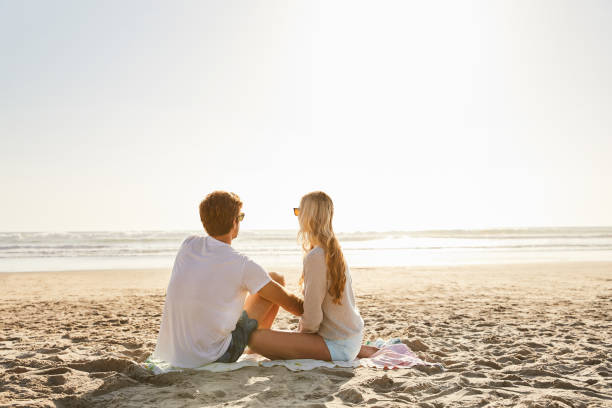 istock Young couple enjoying a relaxing afternoon at the beach 1211595601