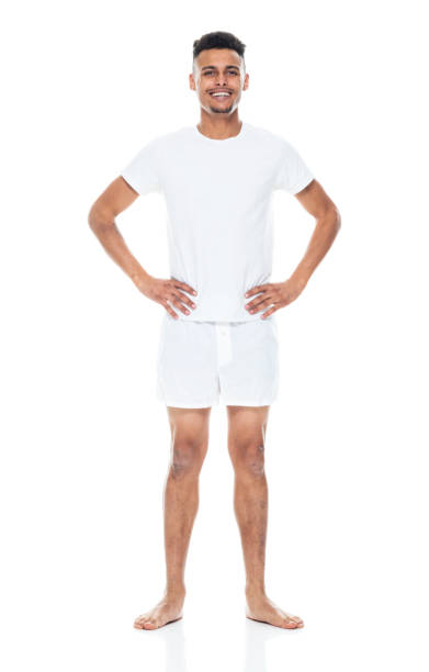 афро-американской этнической принадлежности молодой мужчина, стоящий перед белым фоном носить нижнее белье - underwear men t shirt white стоковые фото и изображения