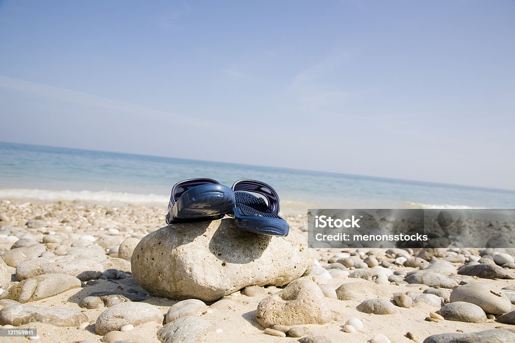 slippers on a rock  Beach Stock Photo