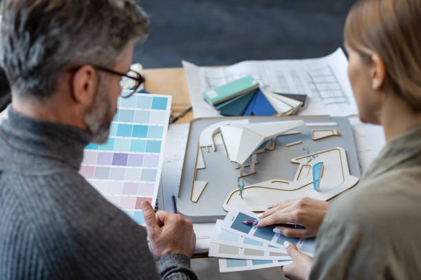 Interior designers team working in office with color palette. Architects select colors for building using color swatches, sketching and planning construction project. Partners discussing at work. equipo de diseñadores de interiores que trabaja en la oficina con paleta de colores. los arquitectos seleccionan colores para construir utilizando muestras de color, esbozo y planificación de proyectos de construcción. socios discutiendo en el trabajo