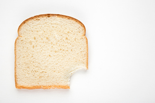 Bitten sandwich white bread slice. Top view close-up.