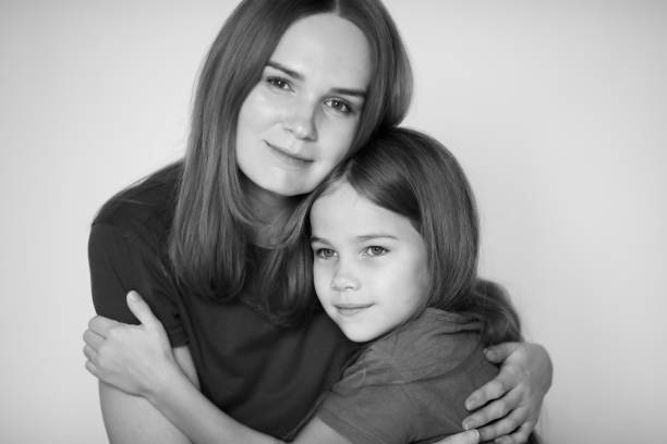 istock mom and daughter hug each. black-white. 1211601626