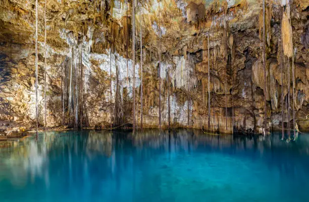 Long exposure of the turquoise waters in Cenote Dzitnup, also known as Xkeken in Maya language. It's a subterranean well near Valladolid, Yucatan Peninsula, Mexico.