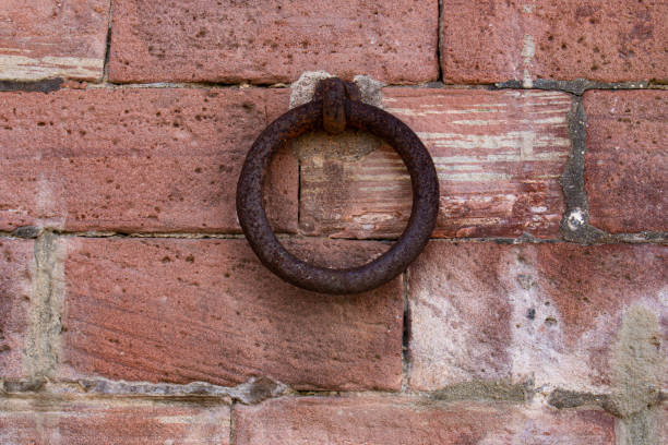 istock Close up of old rusty iron ring on a red brick wall 1211605027