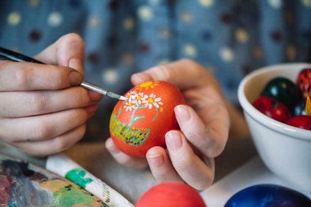 istock Young girl painting on Easter egg 1211605233