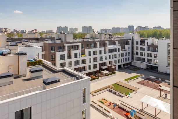 edificio de la casa exterior con techo plano y parque infantil para niños de uso mixto urbano multifamiliar distrito residencial área de desarrollo día soleado - housing development development residential district aerial view fotografías e imágenes de stock