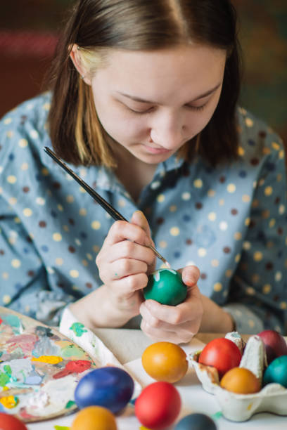 istock Young girl painting on Easter egg 1211605298